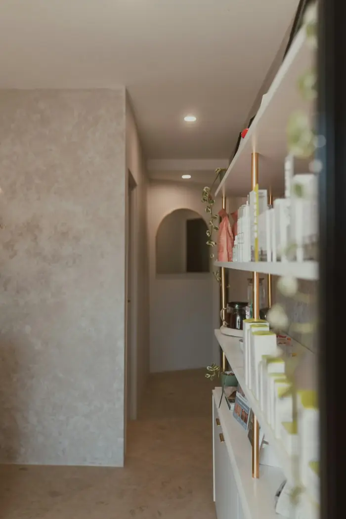 The Maren studio hallway, with arched doorways and shelves of skincare