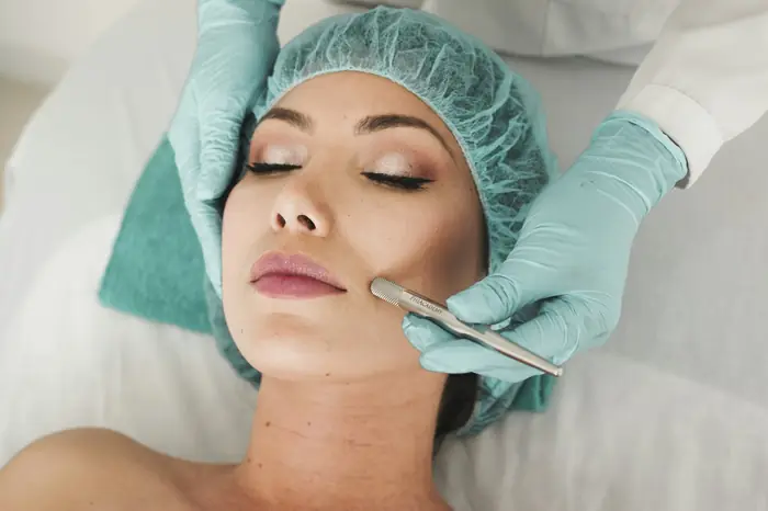 A nurse injector marking a treatment plan on a client’s face