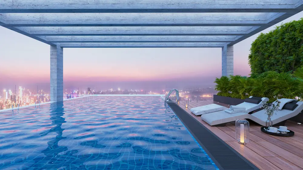 An infinity pool at dusk with the city far below